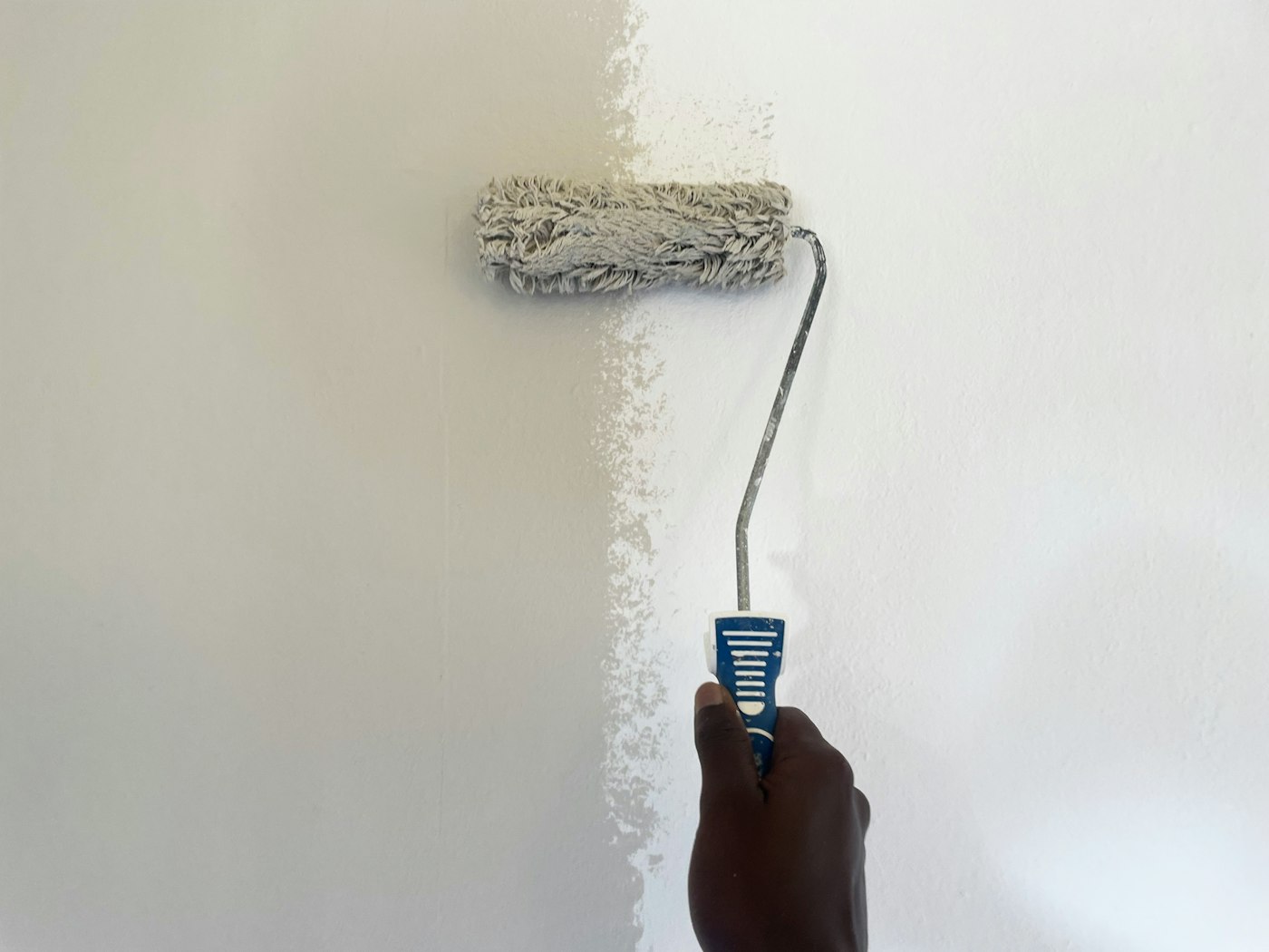 Verfroller op een witte muur