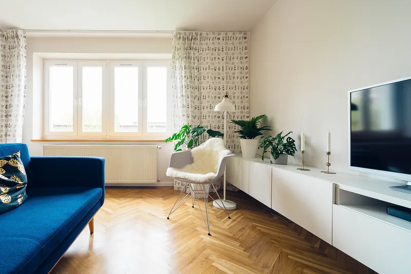 Woonkamer met witte muren en een visgraatparket